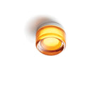 Compact Wall Light - DimpleGlow in smoke beside a bed