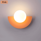 Crescent Moon Wall Lamp – LunaMetal Metal LED Sconce in pink beside a bed